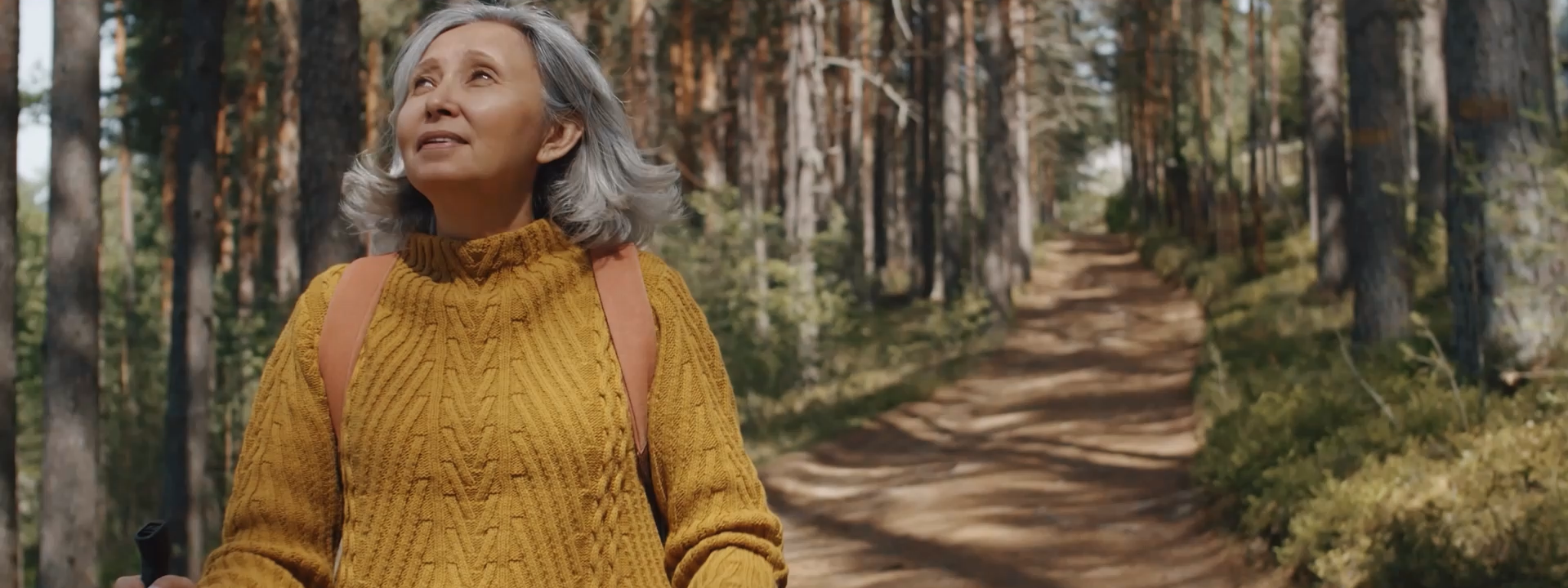 Older woman walking through forest setting